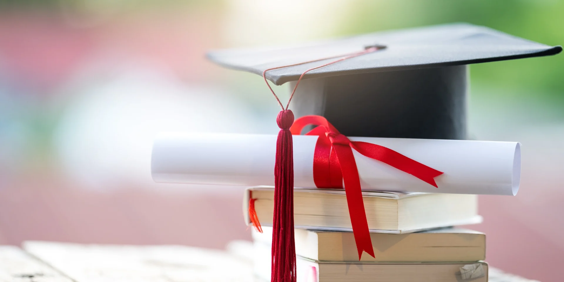 Your Degree is the Start—We Help You Land the Job Graduation cap and diploma with red ribbon resting on a stack of books.