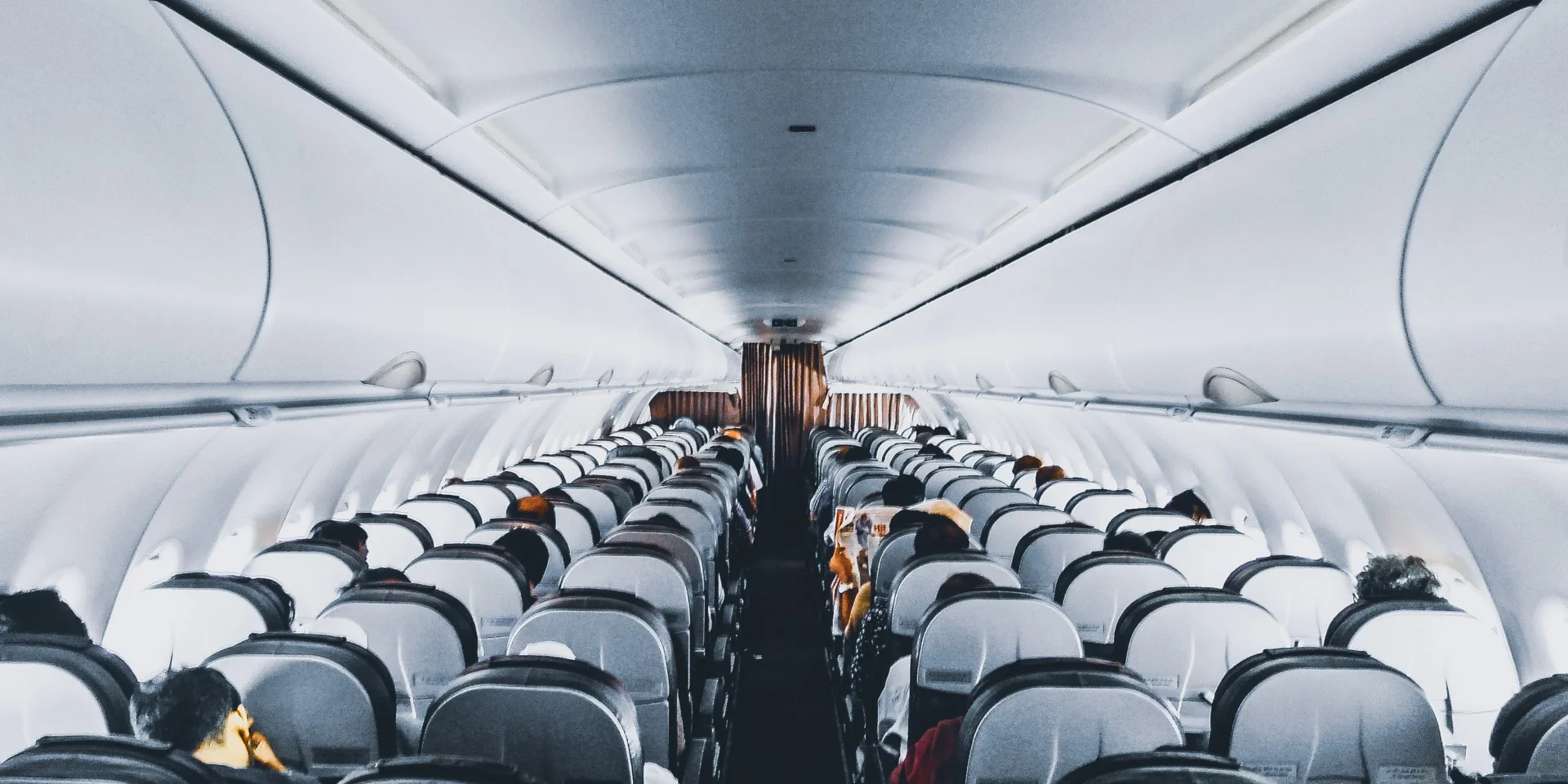 Interior of an airplane cabin with seated passengers.