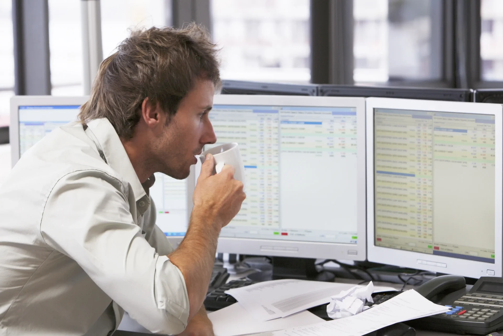 IT Interview Preparation: Businessman at Computer Monitors Businessman looking closely at several computer monitors in a workspace